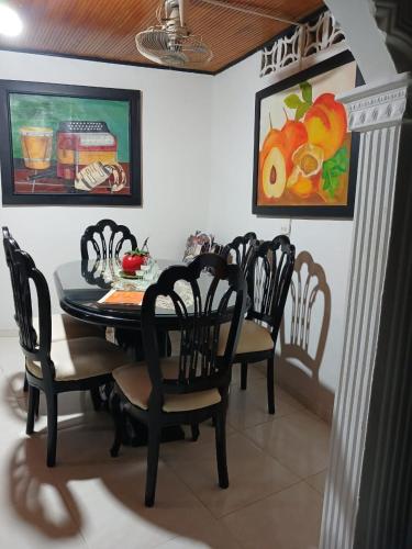 comedor con mesa negra y sillas en Alojamiento festival vallenato, en Valledupar