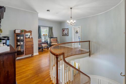 escalera de caracol de madera en la sala de estar en Grand Mansion-Blue Jay suite! en Fort Smith