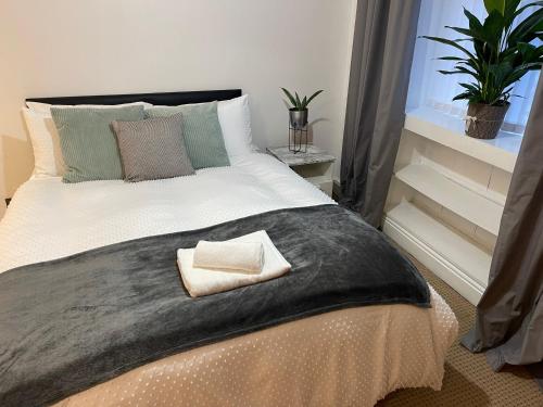 a bedroom with a large bed with a pillow on it at A lovely one bed flat in North Finchley in Finchley