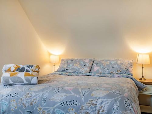a bedroom with a bed with blue sheets and two lamps at 1 Bed in Hawarden 86711 in Hawarden