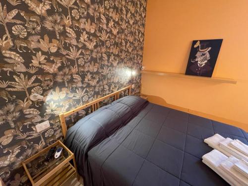 Habitación pequeña con cama y papel pintado con motivos florales en Lattrazionedelgeco, en Terni