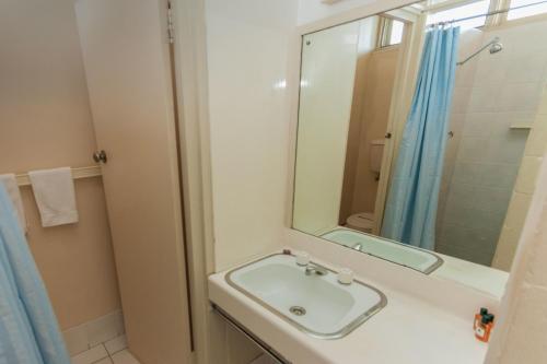 Moruya Waterfront Hotel Motel في مورويا: حمام مع حوض ومرآة