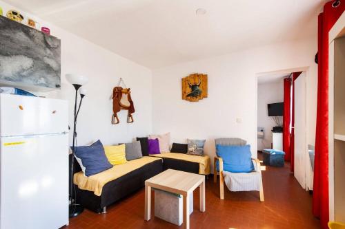 - un salon avec un canapé et un réfrigérateur dans l'établissement Appartement spacieux Saintes-Maries-de-la-Mer 53 m² animaux acceptésEL, à Saintes-Maries-de-la-Mer