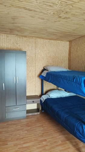 a room with two bunk beds and a cabinet at Casa LLanquihue in Llanquihue