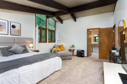 a bedroom with a large bed and a living room at Retro Metro Deck House MCM Gem with Hot Tub & Spectacular Views! in Fairview