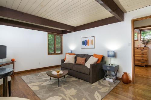 a living room with a couch and a table at Retro Metro Deck House MCM Gem with Hot Tub & Spectacular Views! in Fairview