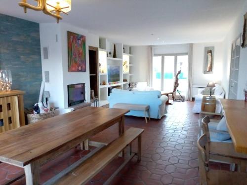un soggiorno con divano e tavolo di Chalet de 3 chambres avec terrasse et wifi a Marck a 1 km de la plage a Marck