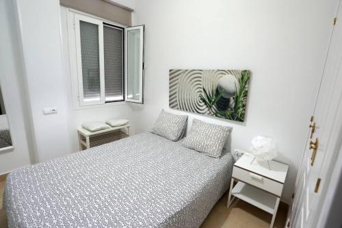 a white bedroom with a bed and two windows at 2 bedrooms appartement with wifi at Arcos de la Frontera in Arcos de la Frontera