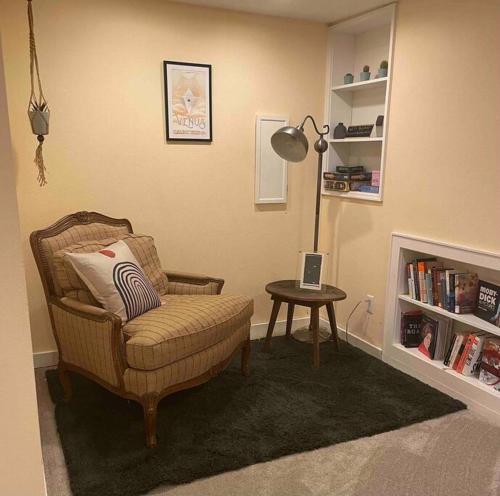 a living room with a chair and a table with a lamp at Sweet Beech St Retreat in Portland