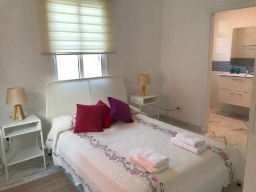 a bedroom with a white bed with towels on it at One bedroom appartement with wifi at San Cristobal de La Laguna 3 km away from the beach in Las Lagunas
