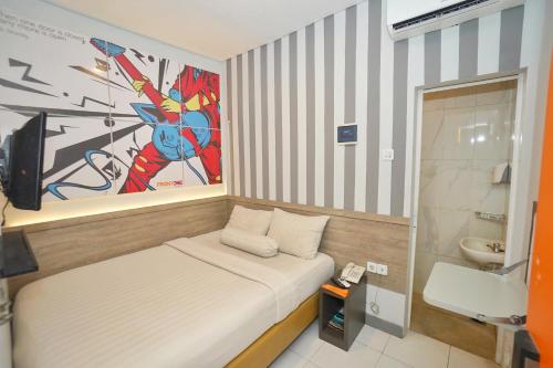 a small room with a bed and a bathroom at Front One Budget Hotel Tirtonadi Solo in Solo