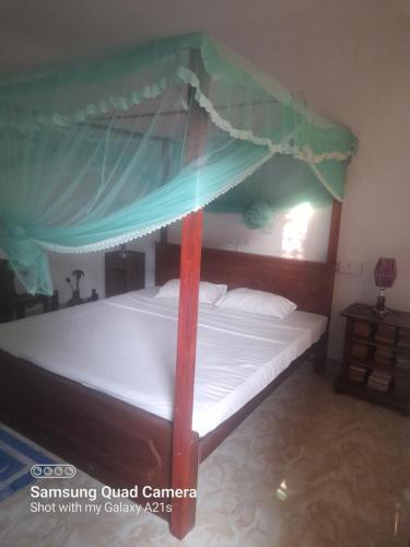 a bed with a canopy in a room at Eura Villa in Bentota