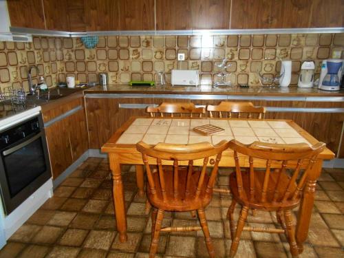 uma cozinha com uma mesa de madeira e 4 cadeiras em Villa de 3 chambres avec piscine privee terrasse et wifi a Landorthe em Landorthe