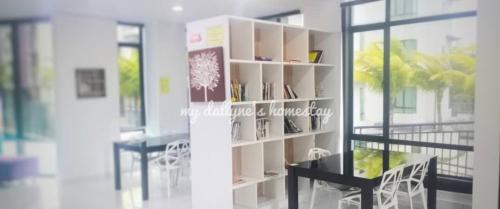 a book shelf in a room with a table and chairs at My Dallyne's Homestay at The Heights Residence, Ayer Keroh, Melaka in Ayer Keroh
