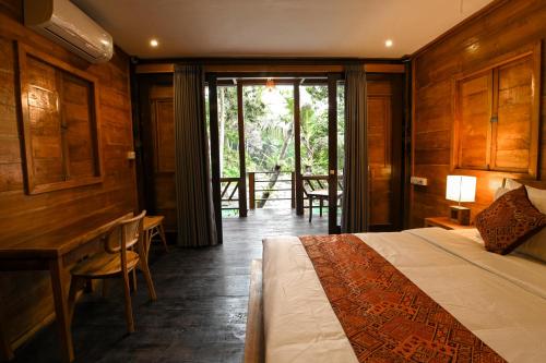 sypialnia z łóżkiem, stołem i krzesłami w obiekcie Tegal Campuhan Retreats w mieście Munggu