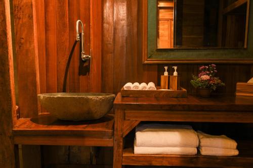 ein Badezimmer mit einem Waschbecken und einem Spiegel in der Unterkunft Tegal Campuhan Retreats in Munggu