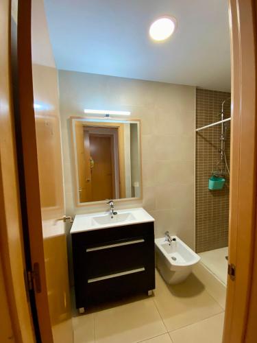 a bathroom with a sink and a toilet and a mirror at Estancias mensuales Terrassa in Terrassa