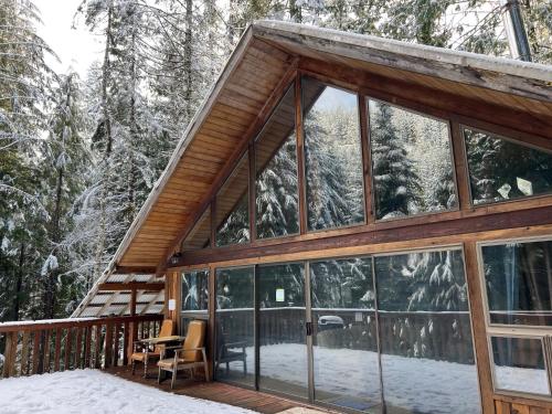 a house with large glass windows on a deck at Chalet at Rainier Lodge (0.4 miles from the entrance) in Ashford