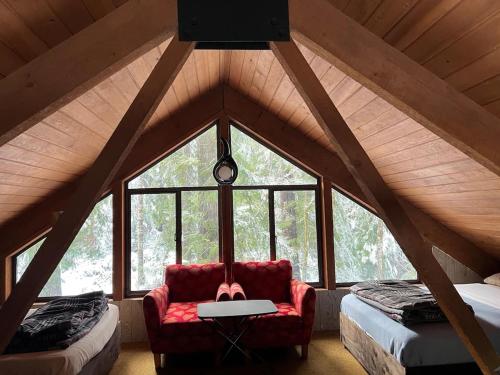 a room with a red couch in a attic at Chalet at Rainier Lodge (0.4 miles from the entrance) in Ashford