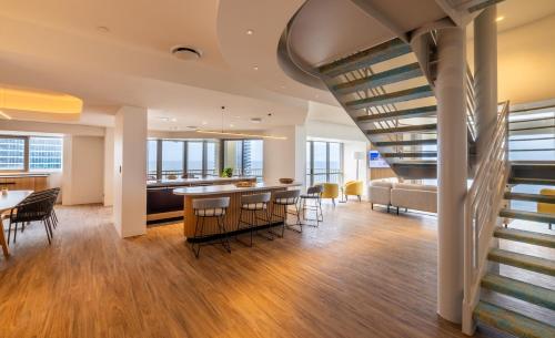 a staircase in a living room with a table and chairs at Novotel Surfers Paradise in Gold Coast