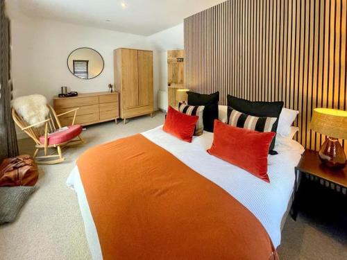 a bedroom with a large bed with red pillows at Eco lodge with hot tub overlooking Cairngorms in Aviemore 