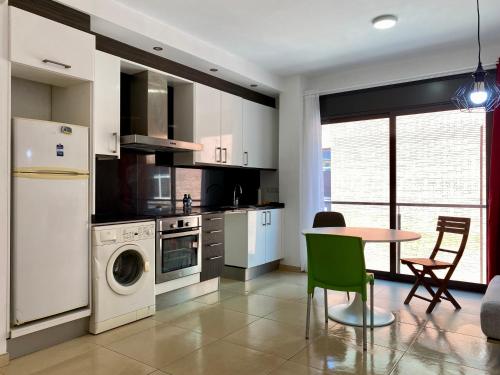 a kitchen with white appliances and a table and chairs at Estancias mensuales Terrassa in Terrassa
