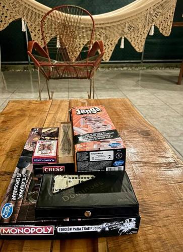 a stack of books on a table with a chair at Cabinas El Jardín in Río Claro