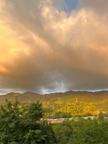 Un ciel nuageux avec des arbres et des montagnes en arrière-plan dans l'établissement Kokol Sinompuru, à Kota Kinabalu