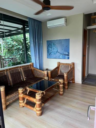 a living room with two couches and a ceiling fan at Kokol Sinompuru in Kota Kinabalu