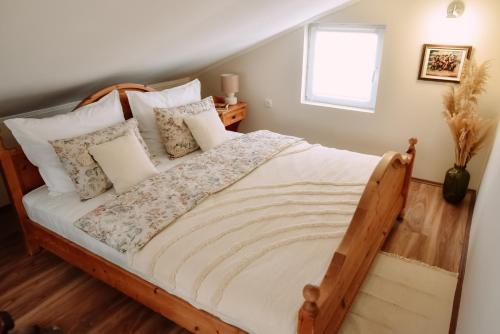 a bedroom with a wooden bed with pillows and a window at Ranch 170 in Subotica