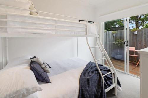 a bedroom with a bunk bed and a balcony at Percy Escape just a walk to Newtown cafes and shops in Geelong