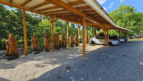a group of wooden statues sitting next to a building at Pensiunea Agroturistica Cerna, Vaideeni - Polovragi in Vaideeni