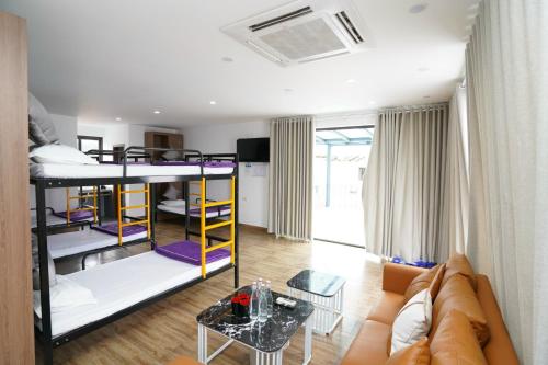 a living room with bunk beds and a couch at Thanh Măng Hotel in Quang Ninh