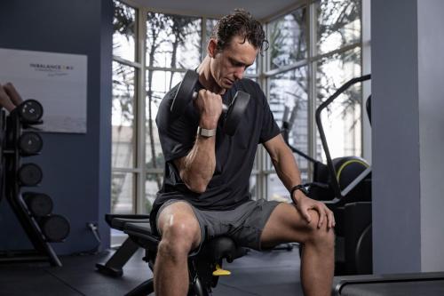 a man sitting on a chair in a gym at Novotel Surfers Paradise in Gold Coast