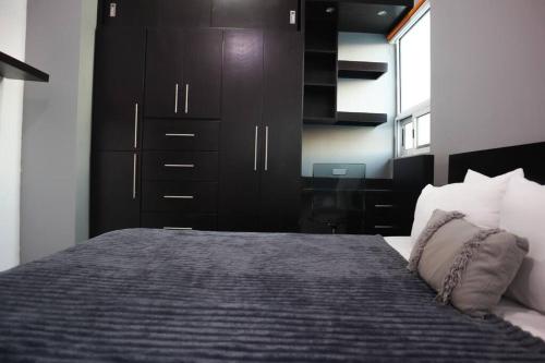 a bedroom with a large bed with a black cabinet at Exclusivo Pent House en el Corazón de Mty,Jacuzzi! -MTY LH10A- in Monterrey