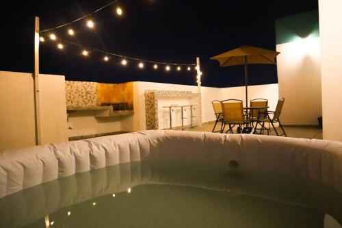 una piscina con luces, sillas y sombrilla en Exclusivo Pent House en el Corazón de Mty,Jacuzzi! -MTY LH10A-, en Monterrey