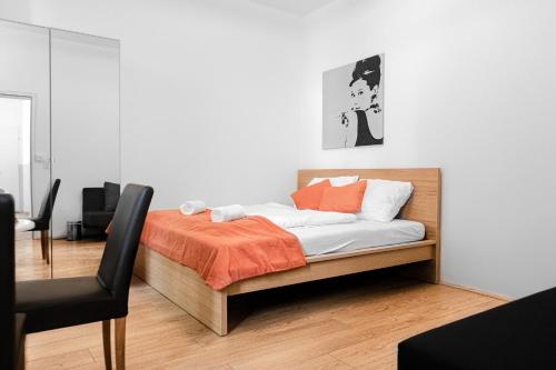 a bedroom with a bed with an orange blanket at Relaxing 2-Bed Apartment for Extended Visits in Vienna