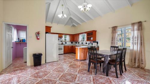 a kitchen with a table and chairs and a refrigerator at Your roomy comfortable place K4 in Morne Rouge