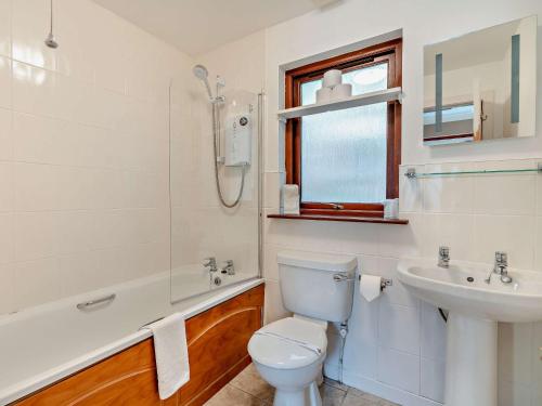 a white bathroom with a toilet and a sink at 1 Bed in Callander 45288 in Saint Fillans