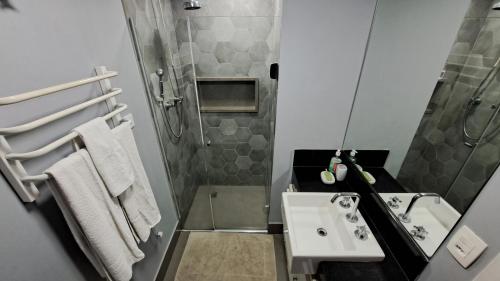 uma casa de banho com um lavatório e um chuveiro em Flat WiFi Ar Piscina Academia Estac Itaim Bibi em São Paulo