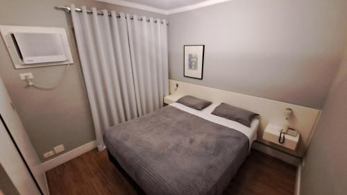 um quarto com uma cama num pequeno quarto em Flat WiFi Ar Piscina Academia Estac Itaim Bibi em São Paulo