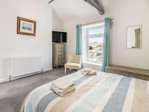 a bedroom with a bed with a chair and a window at 3 bed property in Brixham 88018 in Brixham