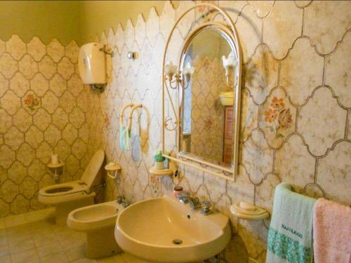 y baño con lavabo, aseo y espejo. en Natural House en Briatico