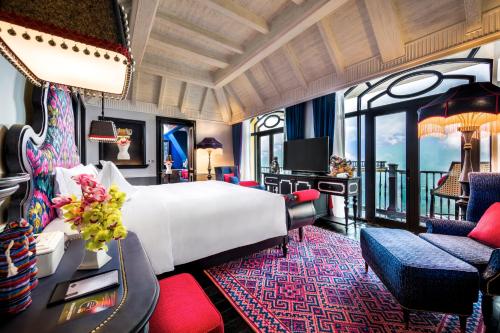 een hotelkamer met een bed, een bureau en stoelen bij Hotel de la Coupole - MGallery in Sa Pa