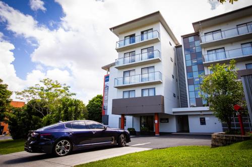 a black car parked in front of a building at Essence Apartments Chermside in Brisbane