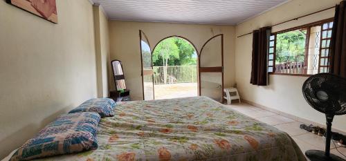 a bedroom with a bed and a large window at Fazenda Araras Eco Turismo - Acesso ilimitado a Cachoeira Araras in Pirenópolis