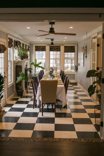 a dining room with a table and chairs on a checkered floor at The Connecticut River Valley Inn Hartford South/Glastonbury in Glastonbury