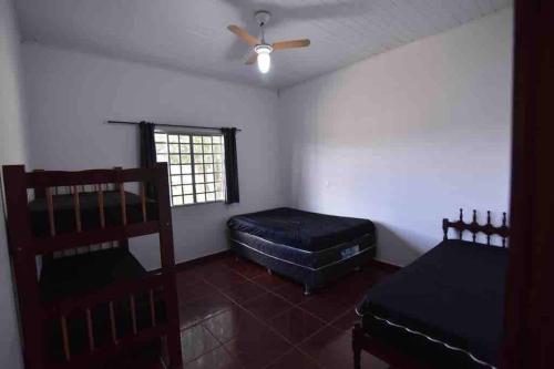 - une chambre avec 2 lits et un ventilateur de plafond dans l'établissement Recanto Minas a Goiás, à Ceres