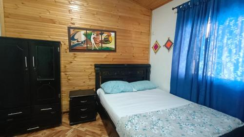 ein Schlafzimmer mit einem Bett mit einem blauen Vorhang und einem Bett mit einem sidx sidx sidx sidx sidx in der Unterkunft Alojamiento Monik in Ríohacha