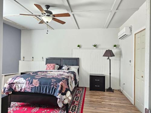 a bedroom with a bed and a ceiling fan at Charming Oasis in Worthville